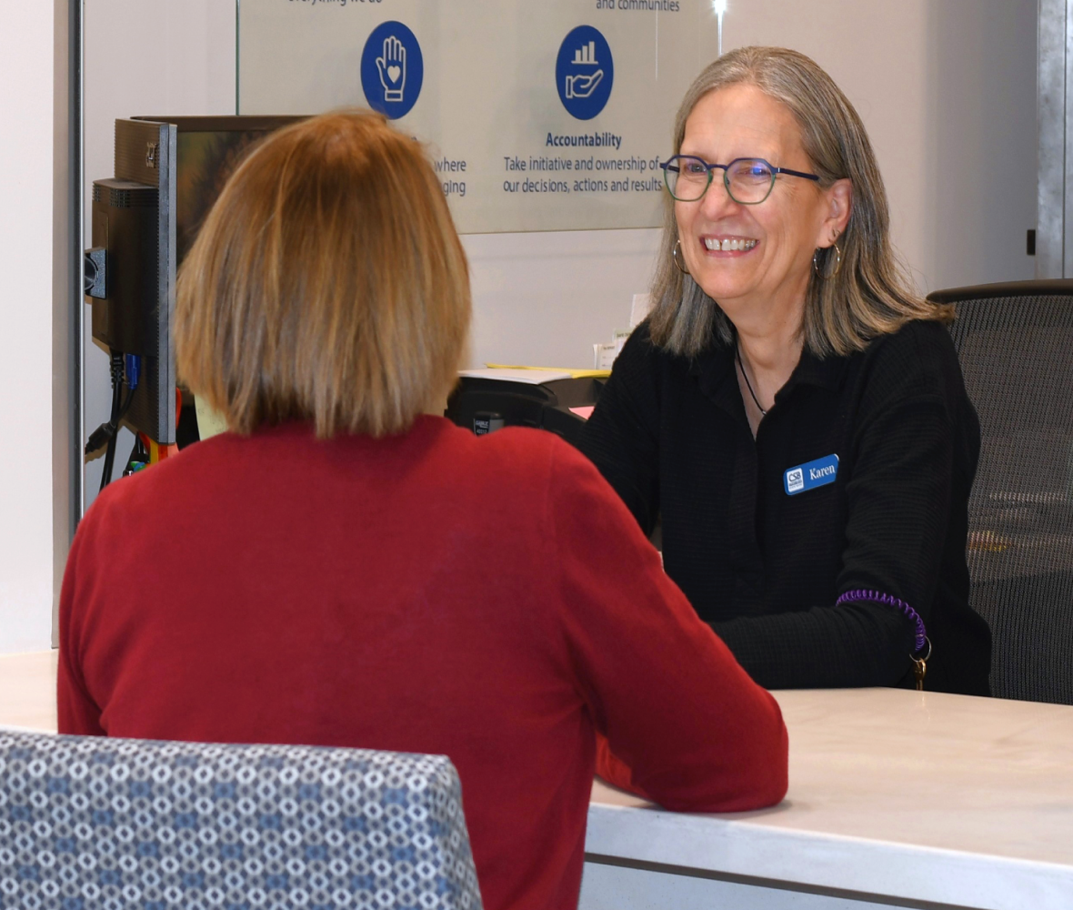 Customer seated at a window with a smiling bank officer