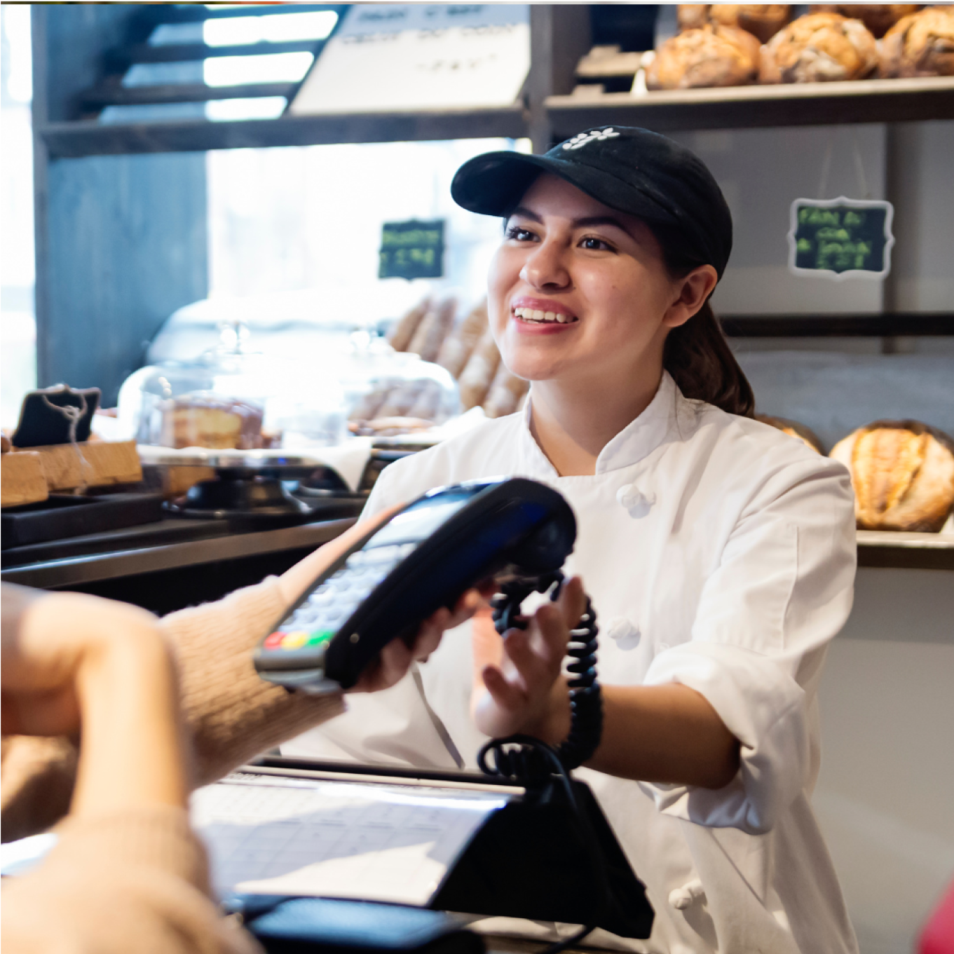 Female bakery worker accepting card payment