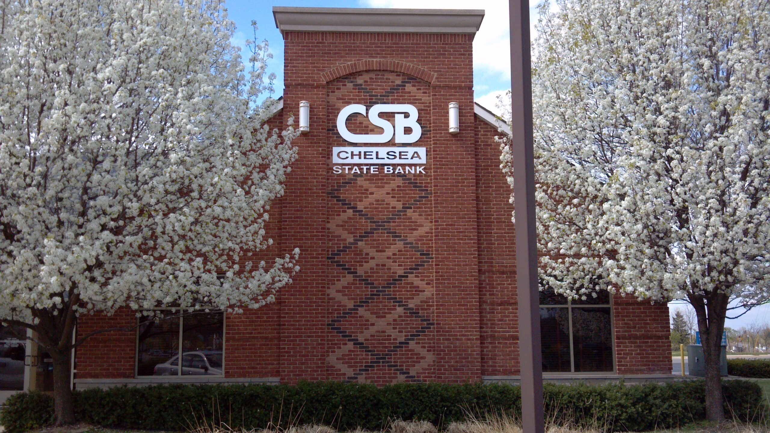 Brick bank building with flowering pear trees