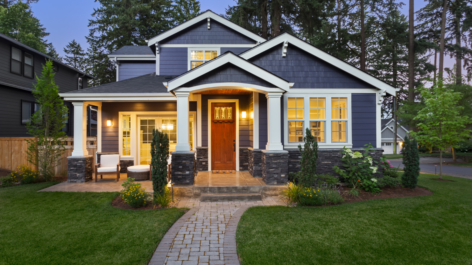 Blue and white house with green lawn in the evening